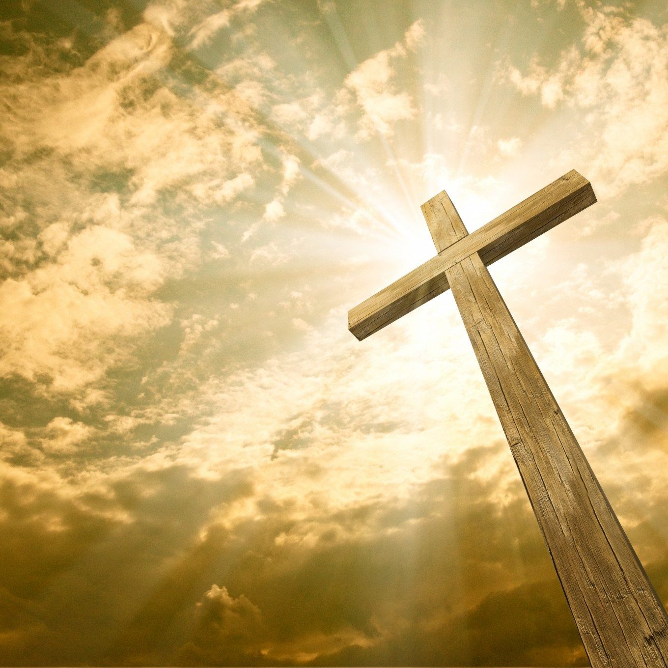 Wooden cross against the sky with shining rays